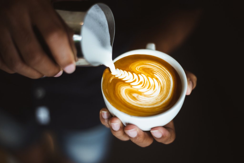 Barista making a cup of coffee latte art.